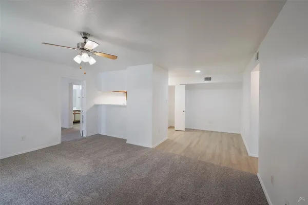 an empty room with windows and fireplace