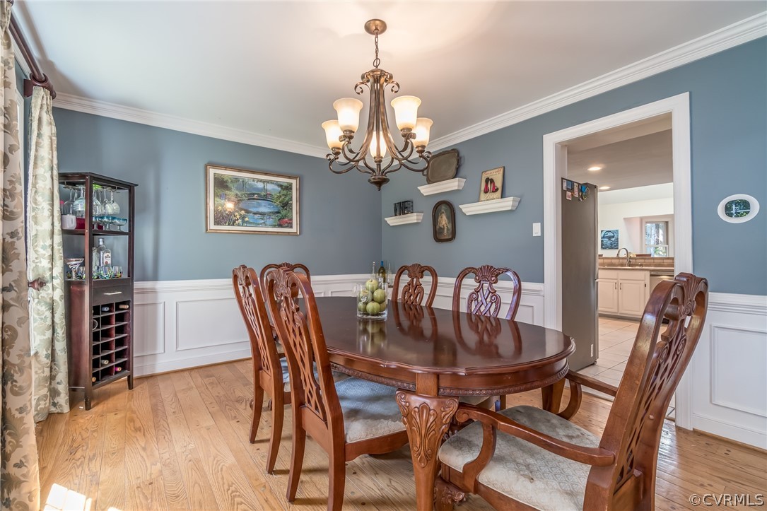 14912 Walnut Bend Road Midlothian, VA 23112 - Photo 8 of 41 a dining room with furniture a chandelier and wooden floor