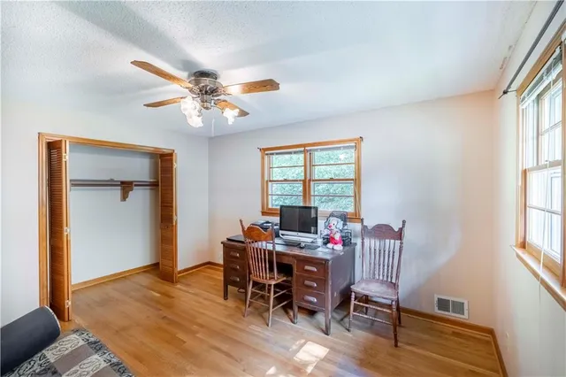 a view of a workspace with furniture and a window