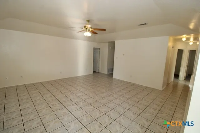 an empty room with chandelier fan