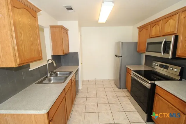 a kitchen with stainless steel appliances a stove a sink and a microwave