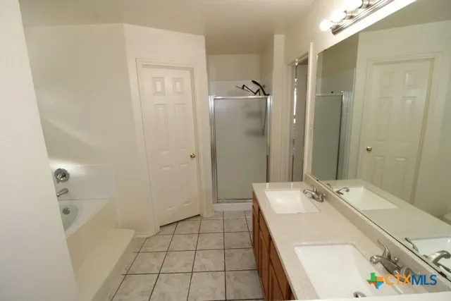 a bathroom with a tub sink and shower