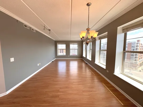 a view of a living room with hardwood floor and windows