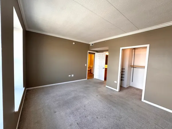 an empty room with an entrance and windows