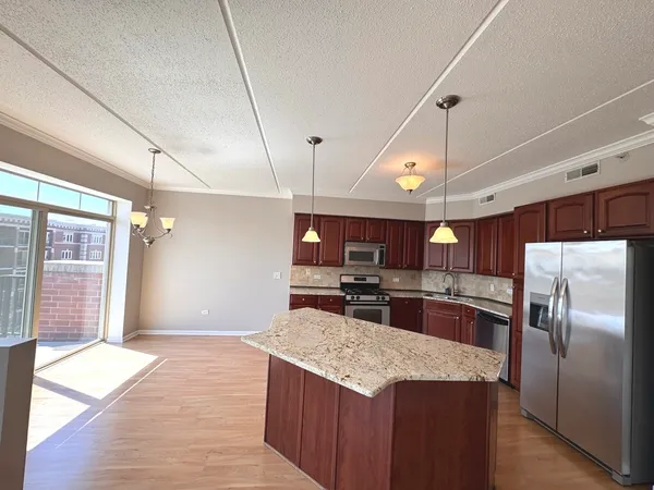 a kitchen with stainless steel appliances granite countertop a sink a stove and a refrigerator