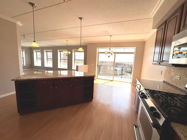 a kitchen with stainless steel appliances granite countertop a stove a sink and a wooden floors
