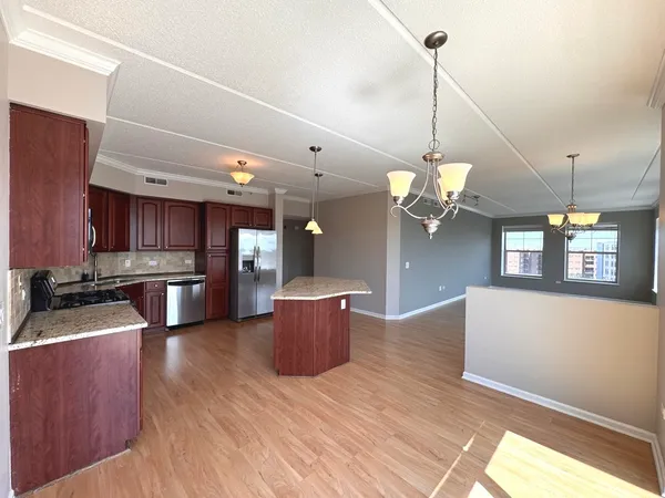a kitchen with stainless steel appliances granite countertop cabinets a stove and a chandelier