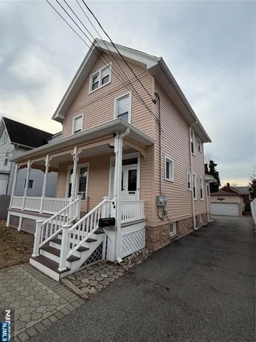 a white house with a large window and wooden fence