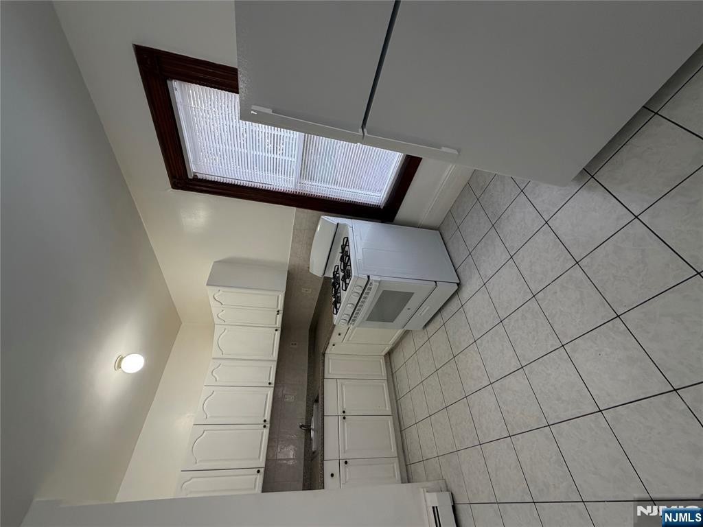 64 Knickerbocker Road, Unit 2 2 Englewood, NJ 07631 - Photo 9 of 27 a kitchen with a sink a stove and cabinets