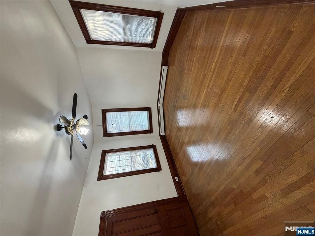 64 Knickerbocker Road, Unit 2 2 Englewood, NJ 07631 - Photo 10 of 27 an empty room with wooden floor chandelier fan and windows