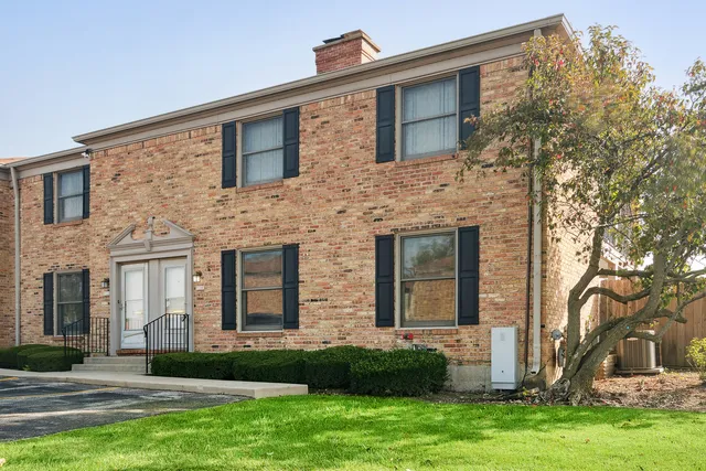 front view of a brick house with a yard