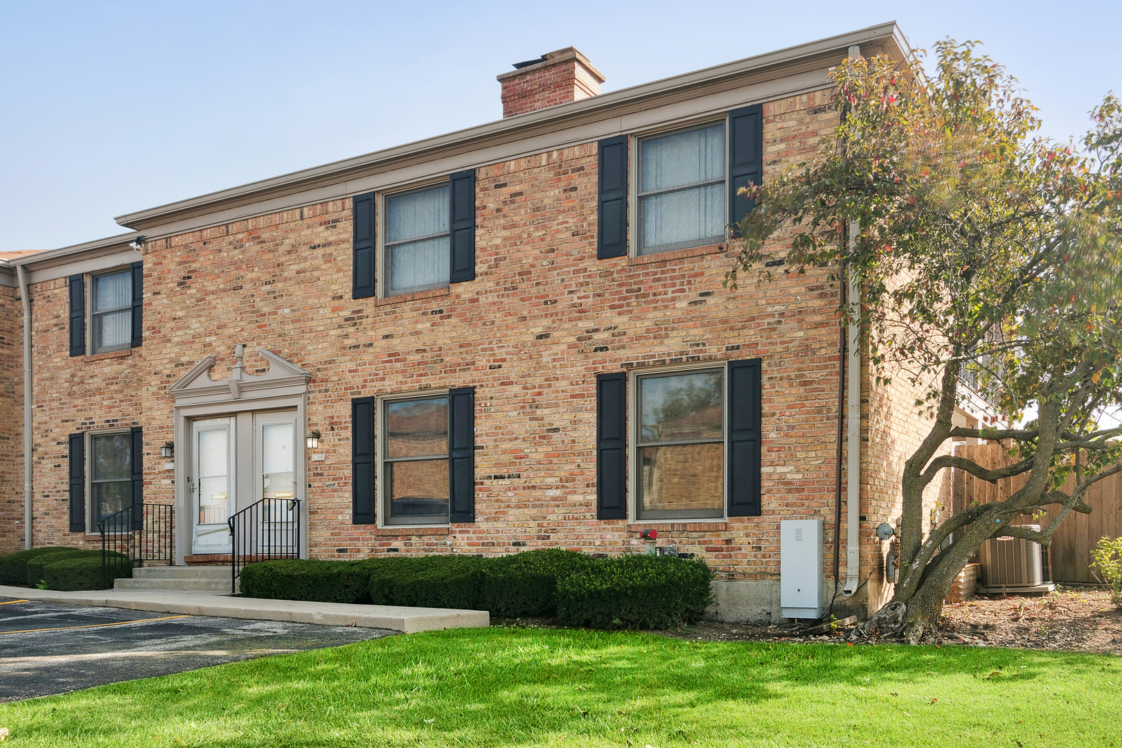 front view of a brick house with a yard