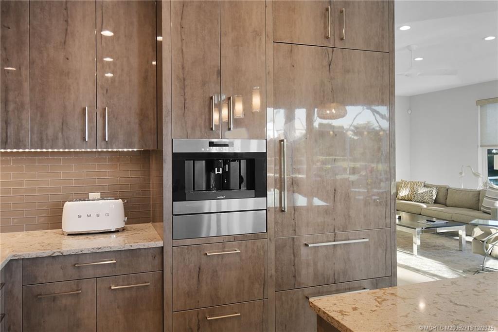 8149 Southeast Double Tree Drive Hobe Sound, FL 33455 - Photo 12 of 61 a kitchen with a sink a refrigerator and cabinets