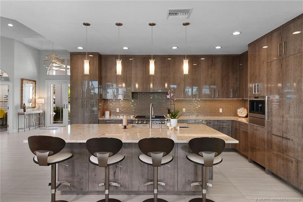 8149 Southeast Double Tree Drive Hobe Sound, FL 33455 - Photo 14 of 61 a kitchen with cabinets and chairs