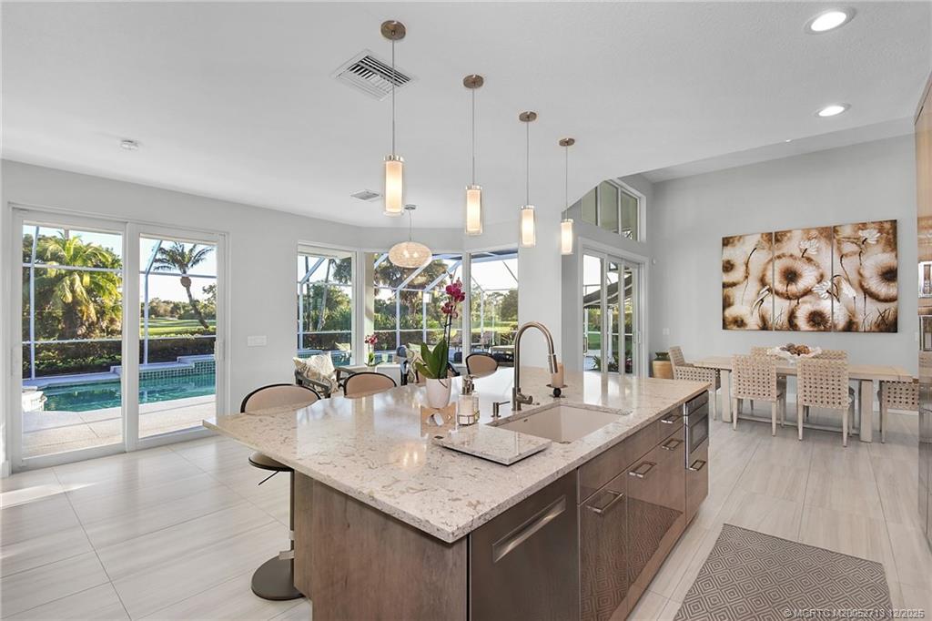 8149 Southeast Double Tree Drive Hobe Sound, FL 33455 - Photo 16 of 61 a kitchen with a table chairs and chandelier