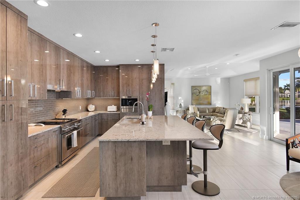 8149 Southeast Double Tree Drive Hobe Sound, FL 33455 - Photo 18 of 61 a large kitchen with lots of counter space a sink and appliances