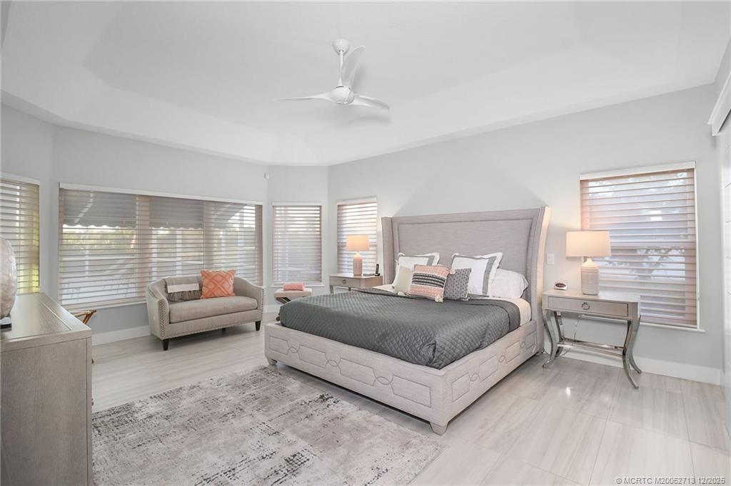 8149 Southeast Double Tree Drive Hobe Sound, FL 33455 - Photo 24 of 61 a spacious bedroom with a bed and large windows
