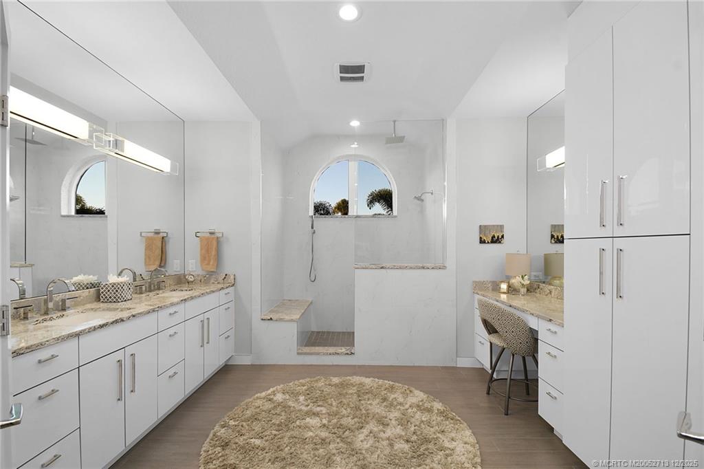 8149 Southeast Double Tree Drive Hobe Sound, FL 33455 - Photo 27 of 61 a spacious bathroom with a granite countertop sink a toilet a mirror and shower