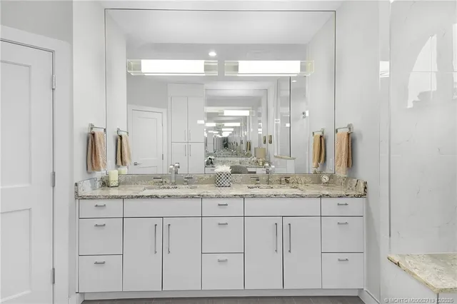 a en suite bathroom with a granite countertop sink and a mirror