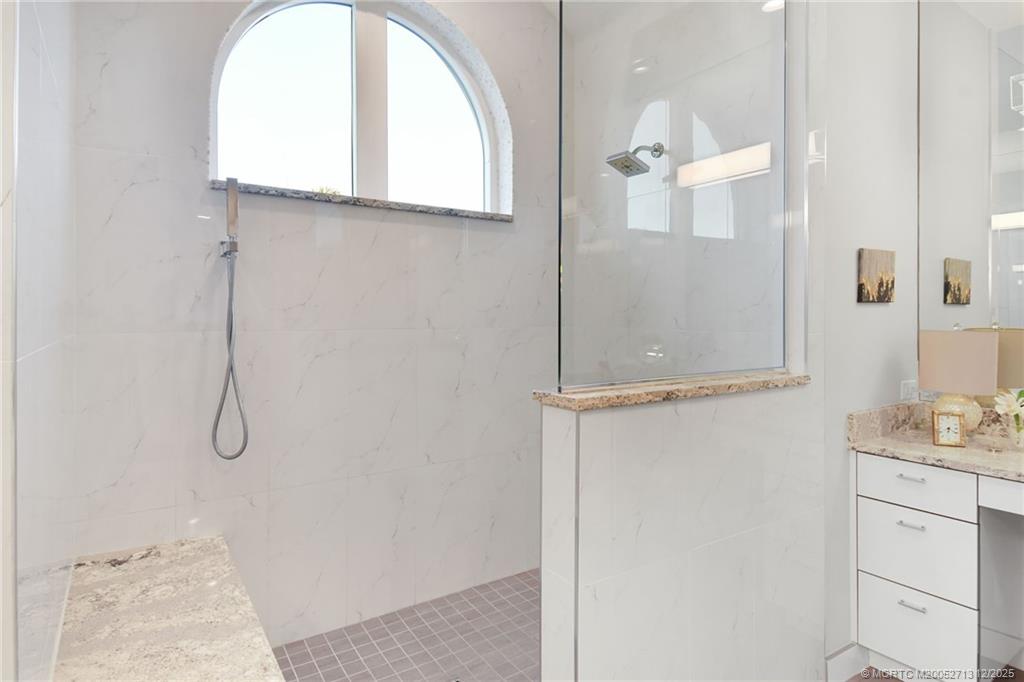 8149 Southeast Double Tree Drive Hobe Sound, FL 33455 - Photo 29 of 61 a bathroom with a granite countertop shower a sink and mirror