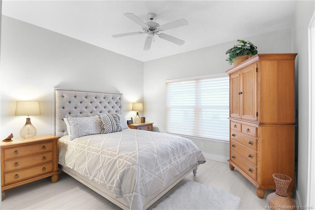 8149 Southeast Double Tree Drive Hobe Sound, FL 33455 - Photo 30 of 61 a bedroom with a bed and a chandelier