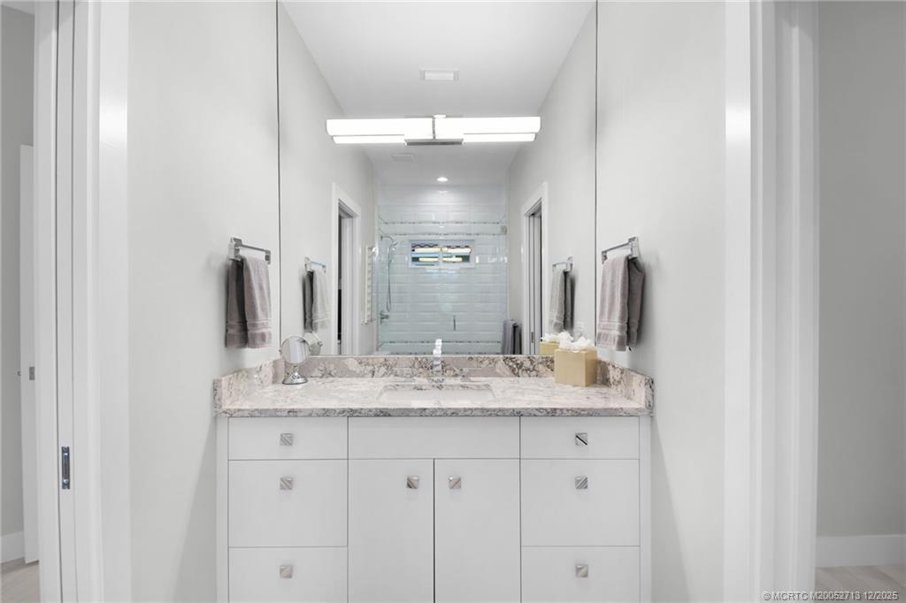 8149 Southeast Double Tree Drive Hobe Sound, FL 33455 - Photo 32 of 61 a bathroom with a granite countertop sink and a mirror