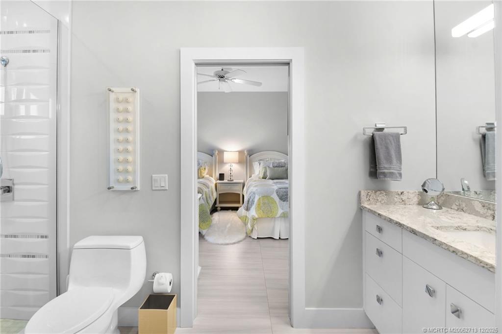 8149 Southeast Double Tree Drive Hobe Sound, FL 33455 - Photo 33 of 61 a en suite bathroom with a granite countertop sink and a mirror