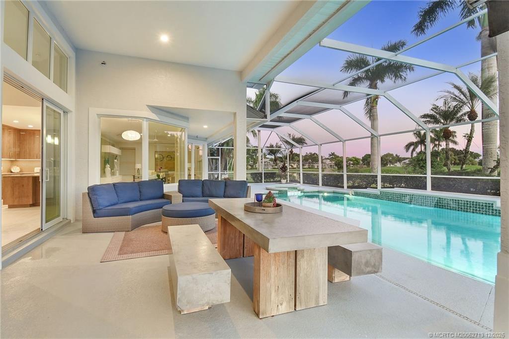 8149 Southeast Double Tree Drive Hobe Sound, FL 33455 - Photo 38 of 61 a view of a living room and kitchen floor to ceiling windows