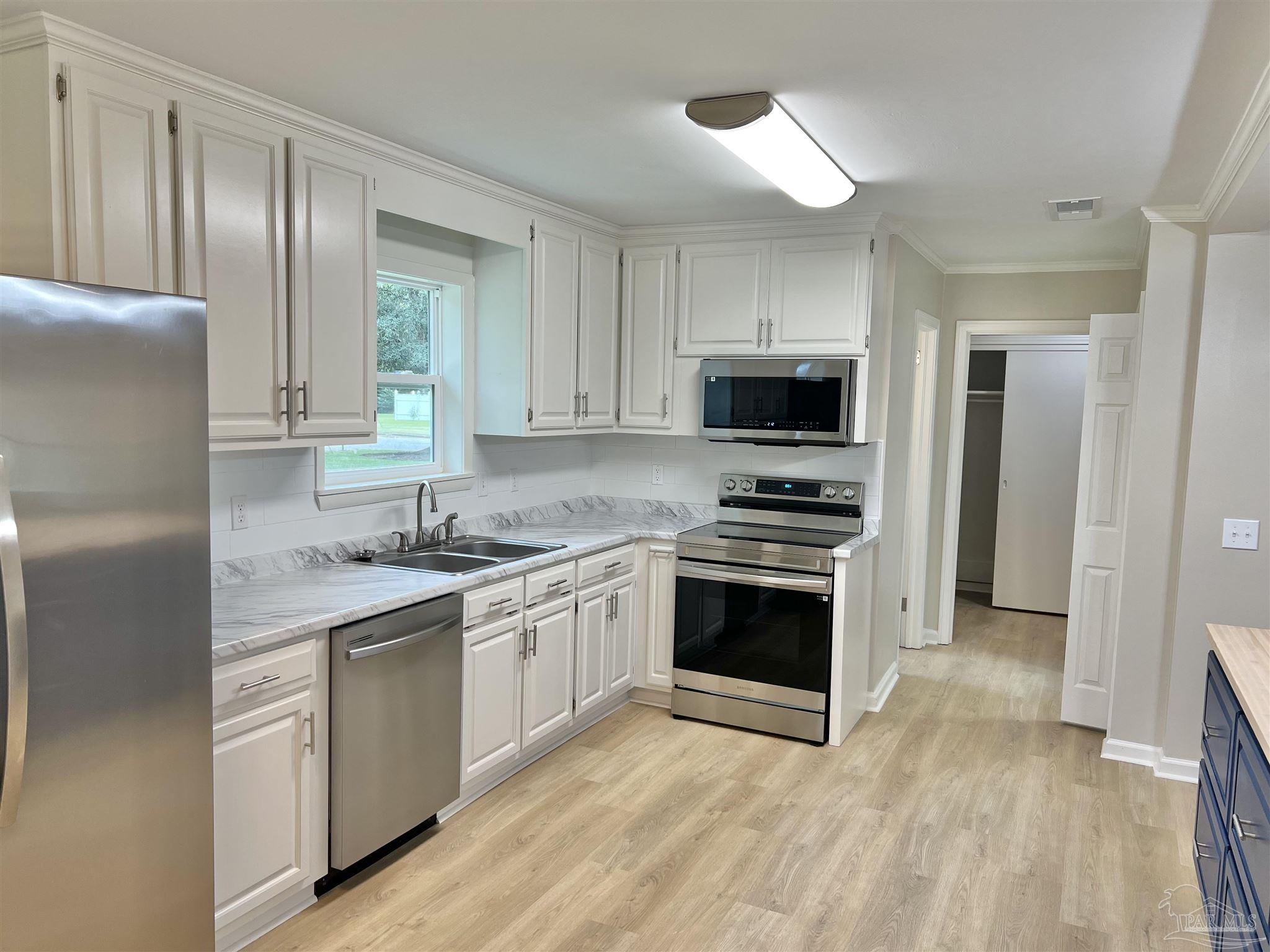 618 South Carney Street Atmore, AL 36502 - Photo 15 of 39 a kitchen with stainless steel appliances granite countertop a stove top oven a sink and a refrigerator