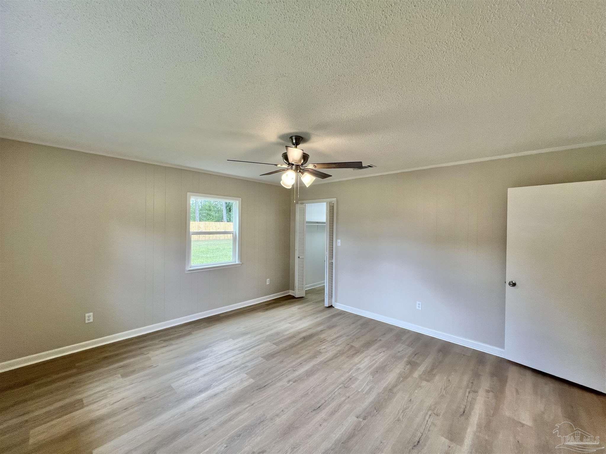 618 South Carney Street Atmore, AL 36502 - Photo 26 of 39 an empty room with wooden floor fan and windows