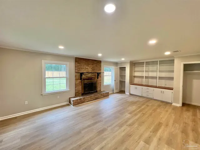 an empty room with wooden floor and fireplace