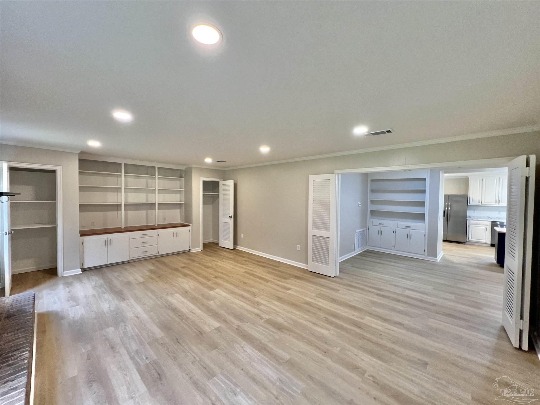 618 South Carney Street Atmore, AL 36502 - Photo 4 of 39 an empty room with wooden floor closet and windows