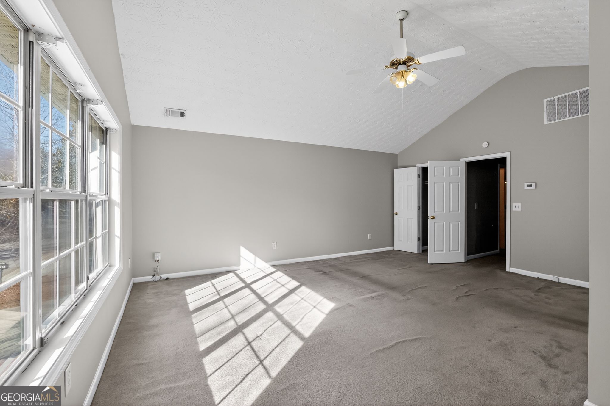 6256 Lake Valley Point Lithonia, GA 30058 - Photo 6 of 33 an empty room with chandelier fan and windows