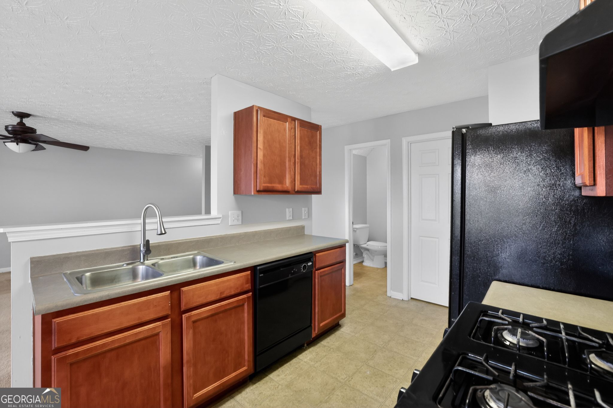 6256 Lake Valley Point Lithonia, GA 30058 - Photo 9 of 33 a kitchen with a sink stove and refrigerator