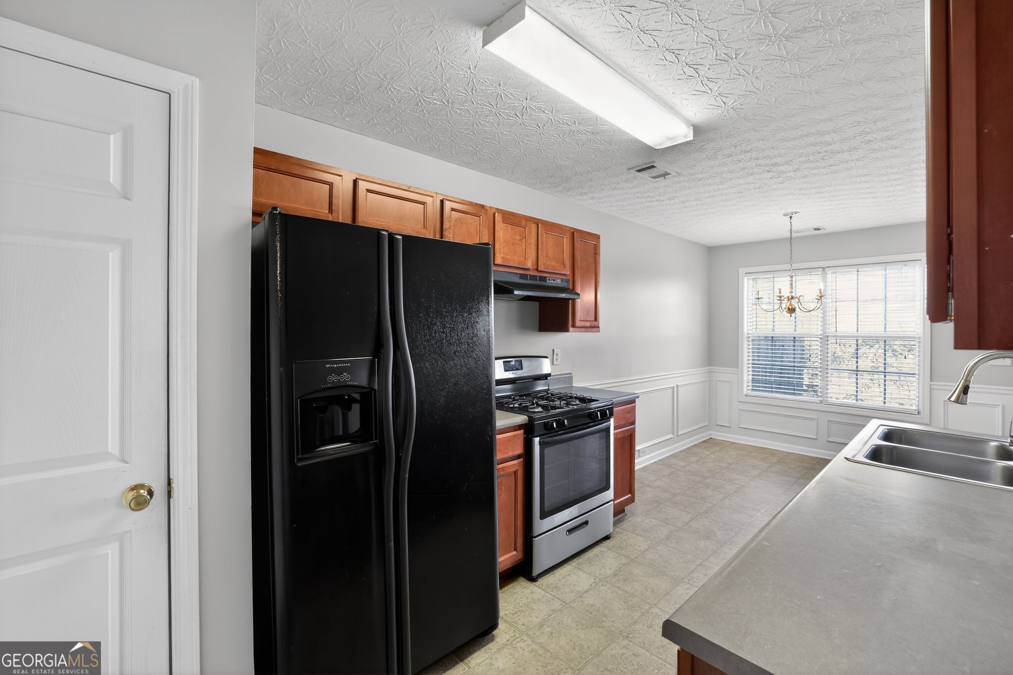 6256 Lake Valley Point Lithonia, GA 30058 - Photo 10 of 33 a kitchen with stainless steel appliances granite countertop a refrigerator and a sink