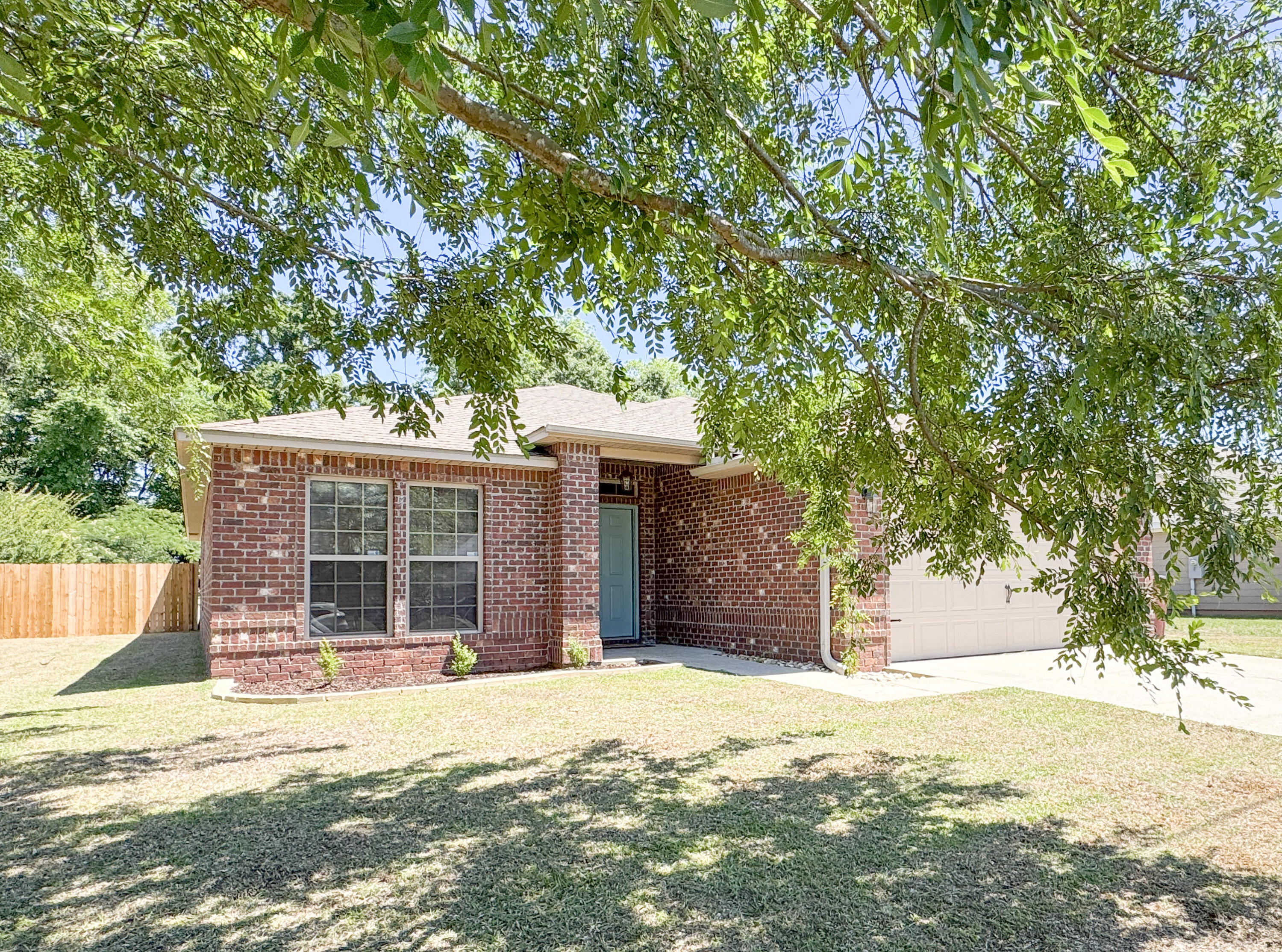 a view of a house with backyard and tree