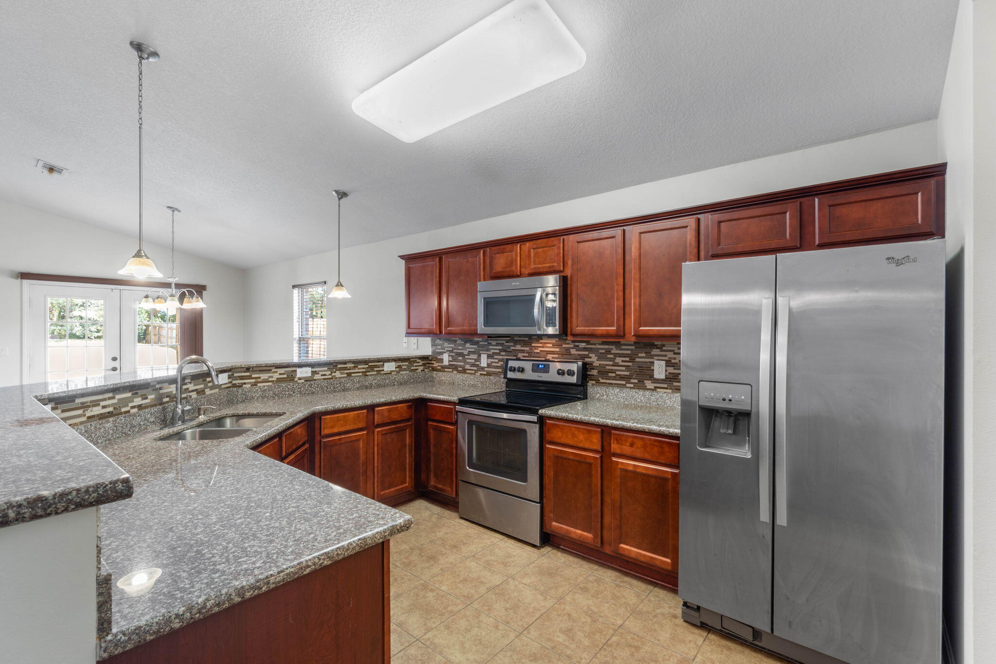 5609 Price Plantation Road Baker, FL 32531 - Photo 11 of 49 a kitchen with stainless steel appliances granite countertop a sink stove microwave and refrigerator