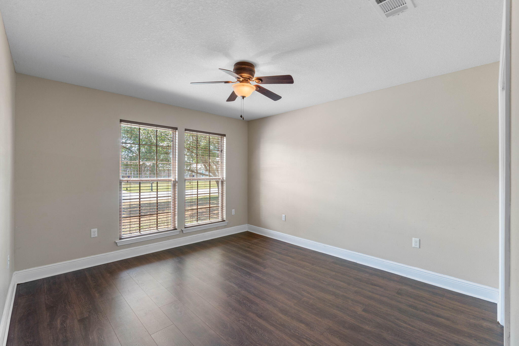 5609 Price Plantation Road Baker, FL 32531 - Photo 20 of 49 an empty room with wooden floor ceiling fan and windows