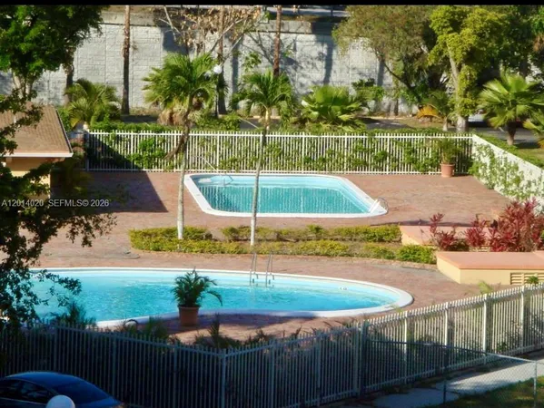 an outdoor space with swimming pool and green space
