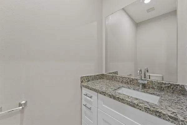 a bathroom with a granite countertop sink and vanity