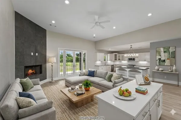 a living room with furniture kitchen view and a large window