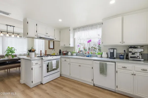 a kitchen with white cabinets and white appliances