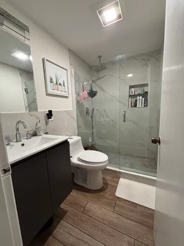 a bathroom with a sink toilet a mirror and shower