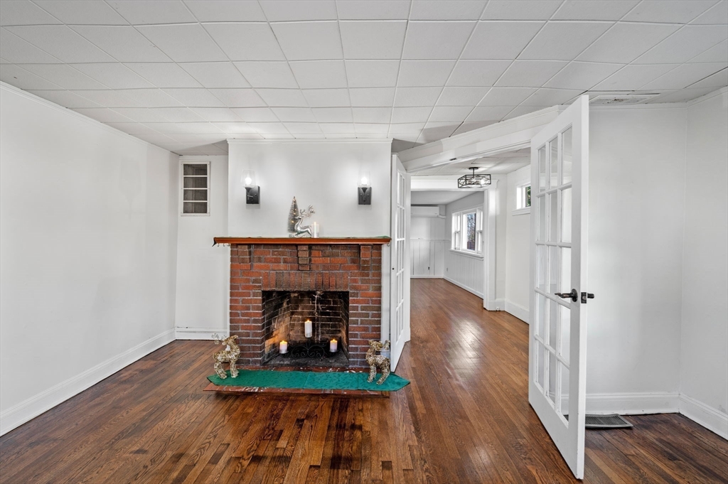 268 Walnut Street Lynn, MA 01905 - Photo 8 of 42 an empty room with wooden floor fireplace and staircase