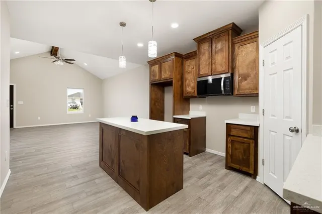 a kitchen with stainless steel appliances granite countertop a refrigerator a stove and a wooden floors