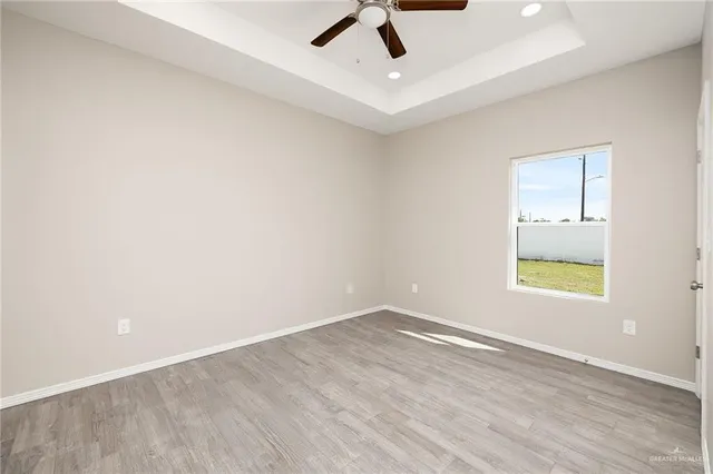 an empty room with a window and ceiling fan