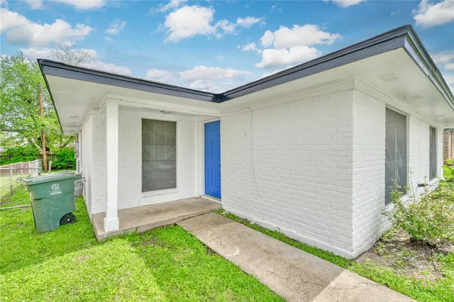 a view of an empty room with wooden floor and a ceiling fan