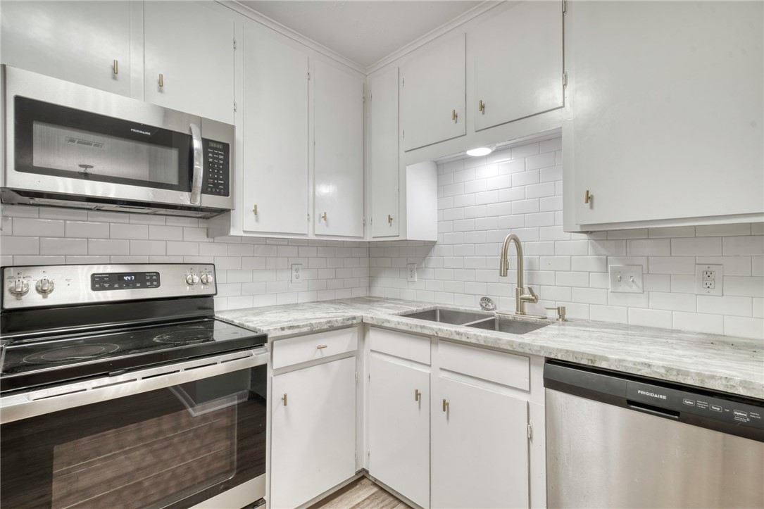 3911 Olive Street, Unit B Bryan, TX 77801 - Photo 5 of 12 a kitchen with appliances a sink and cabinets