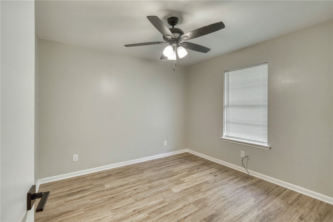 3911 Olive Street, Unit B Bryan, TX 77801 - Photo 7 of 12 an empty room with wooden floor fan and windows