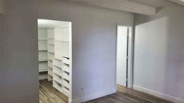 a view of walk in closet with empty racks